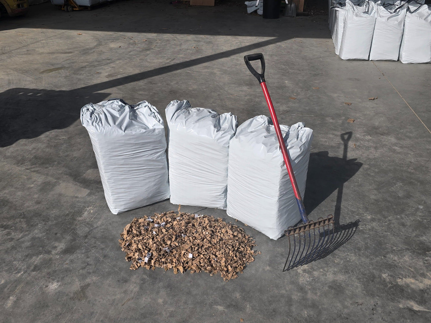 Three bales of ShredEase bedding with loose sample spread on the floor